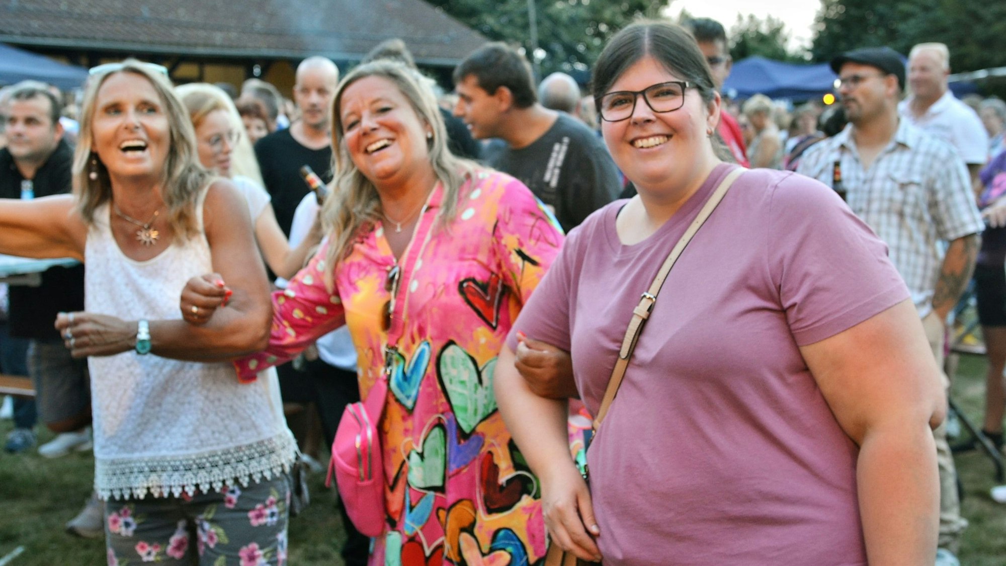 Drei Frauen schunkeln fröhlich.