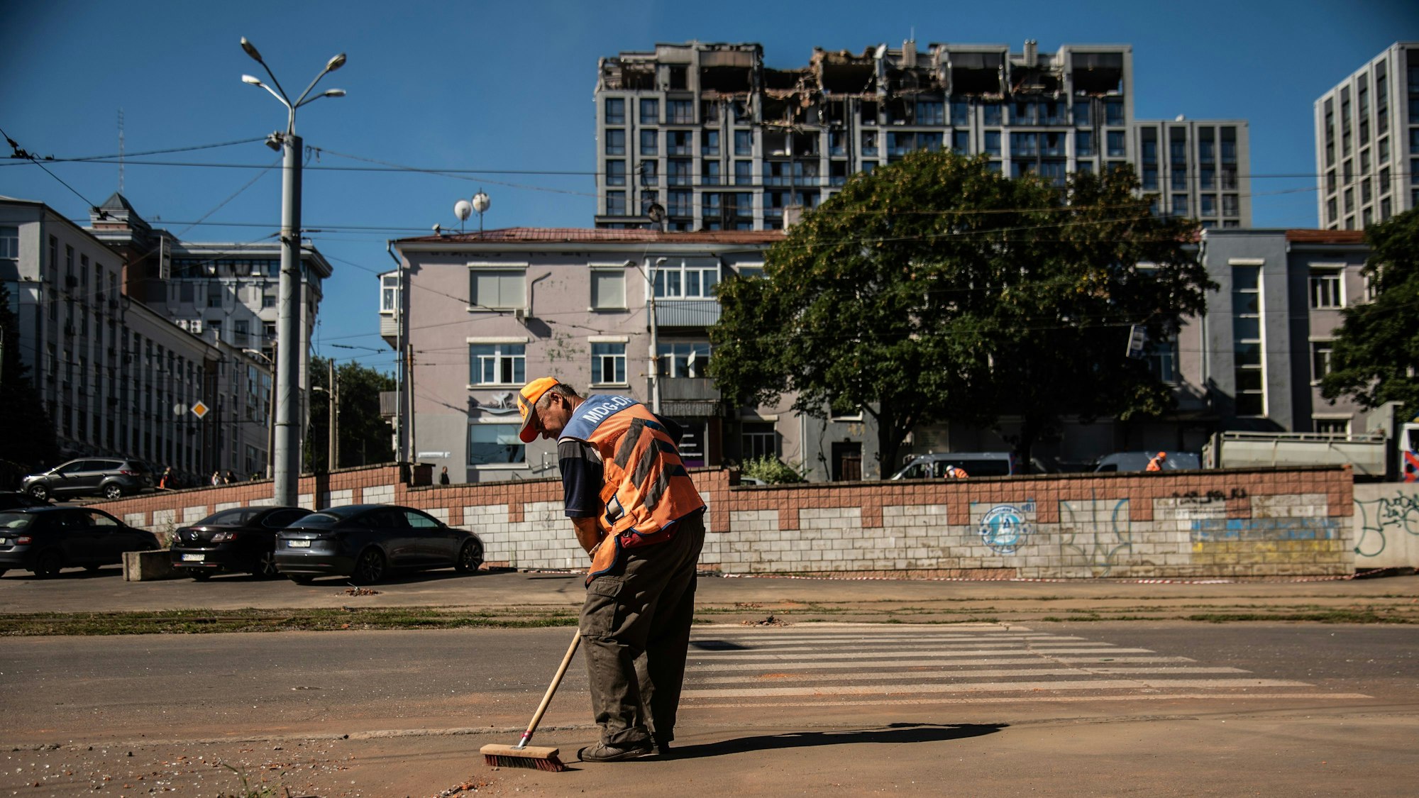Reinigungskräfte führen Arbeiten in der Nähe eines angegriffenen Verwaltungsgebäudes durch.