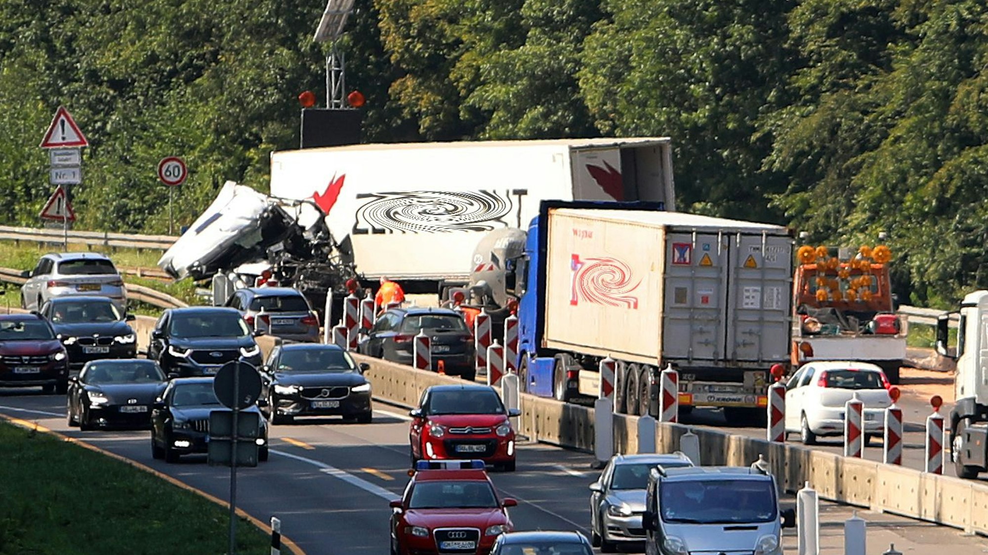 Ein schwer beschädigter Lkw steht in der Nacht (27.8.) auf der A4 bei Bensberg. Feuerwehr und Polizei sind im Einsatz, die Unfallstelle ist ausgeleuchtet.