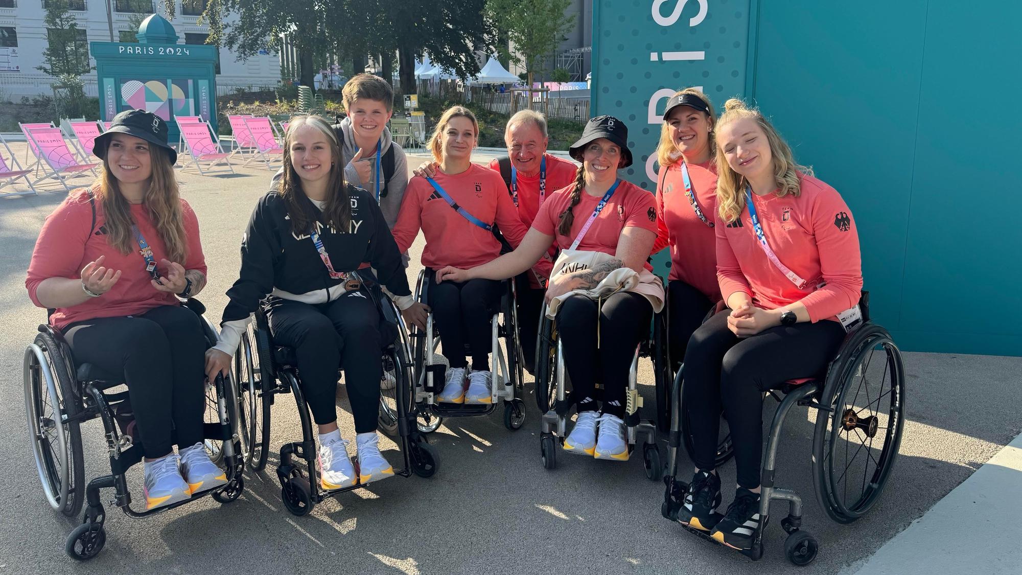 Mehrere Frauen und Männer in Rollstühlen bei den Paralympics in Paris.