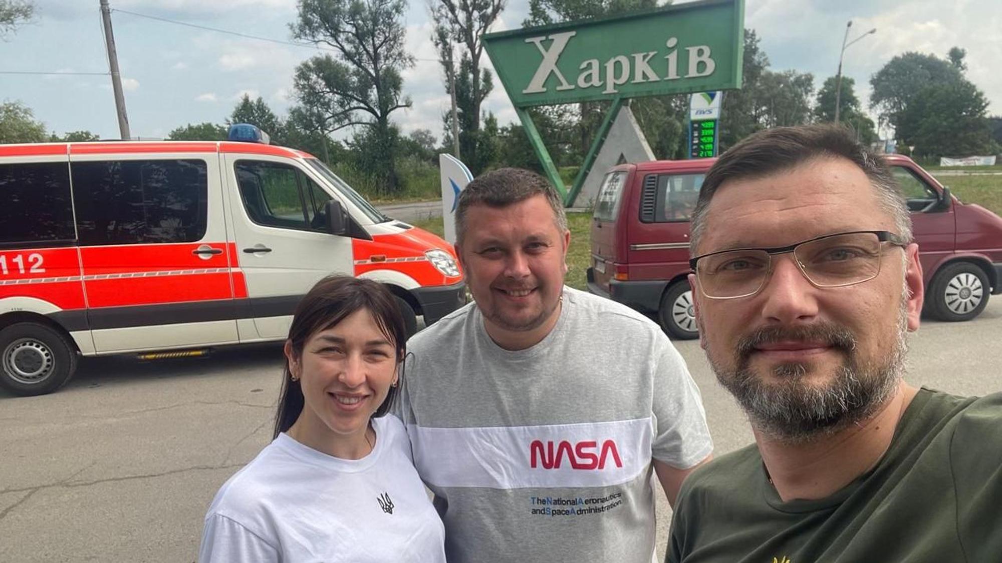 Ein Mann macht ein Selfie von sich und einem Krankenwagen im Hintergrund.