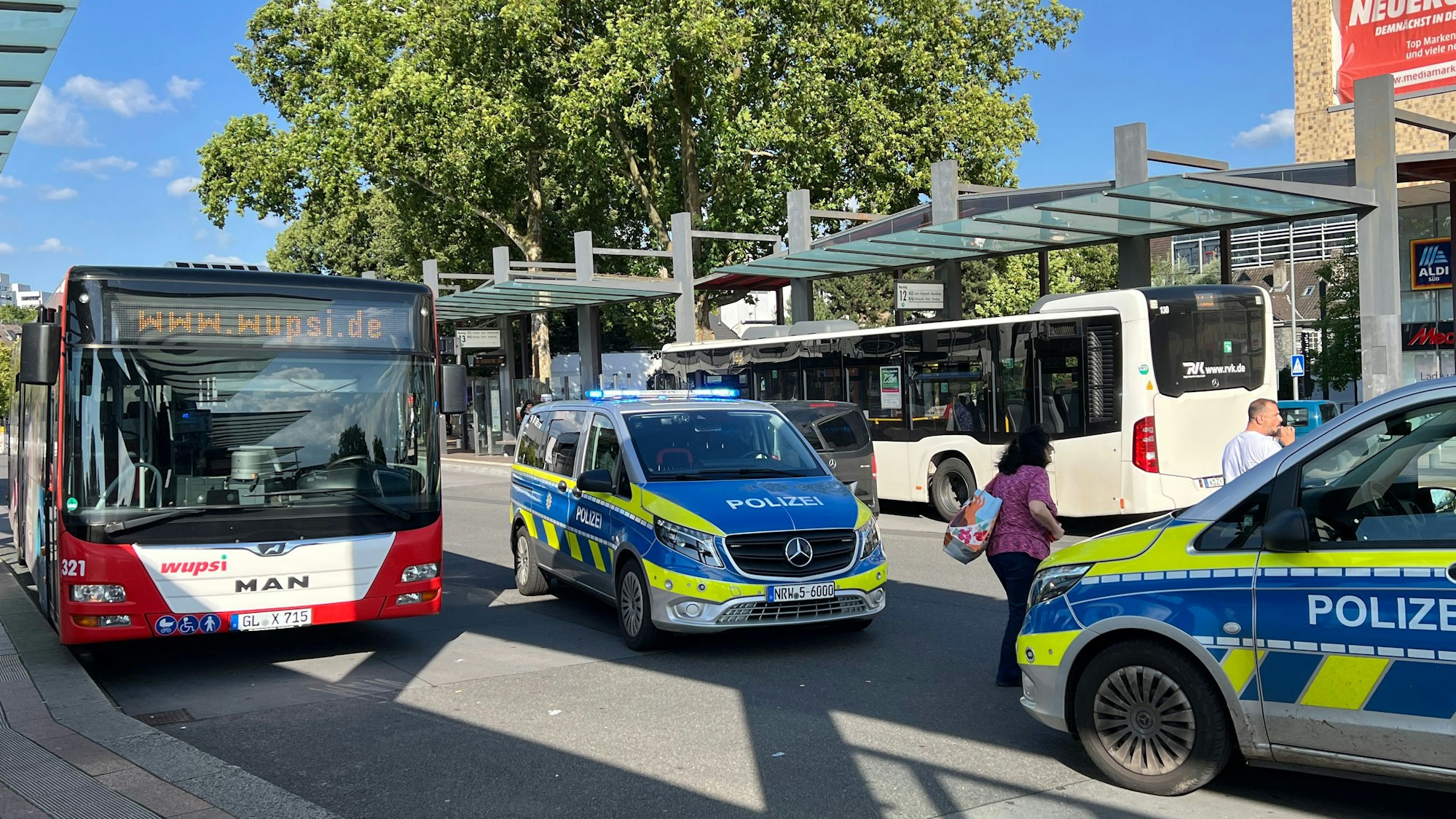 Zwei Polizeifahrzeuge mit eingeschaltetem Blaulicht stehen auf dem Bergisch Gladbacher Busbahnhof