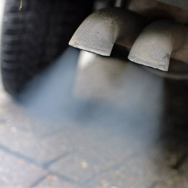 Abgase strömen aus dem Auspuff eines Fahrzeuges mit Dieselmotor.