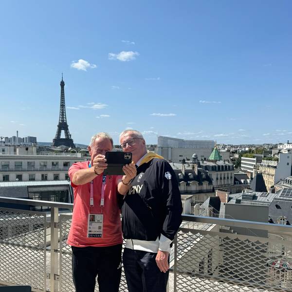 Zwei Männer machen im Rahmen der Paralympics in Paris ein Selfie mit dem Eiffelturm im Hintergrund.