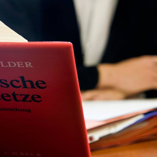Ein Anwalt sitzt hinter der aufgeschlagenen „Schönfelder Textsammlung Deutsche Gesetze“.