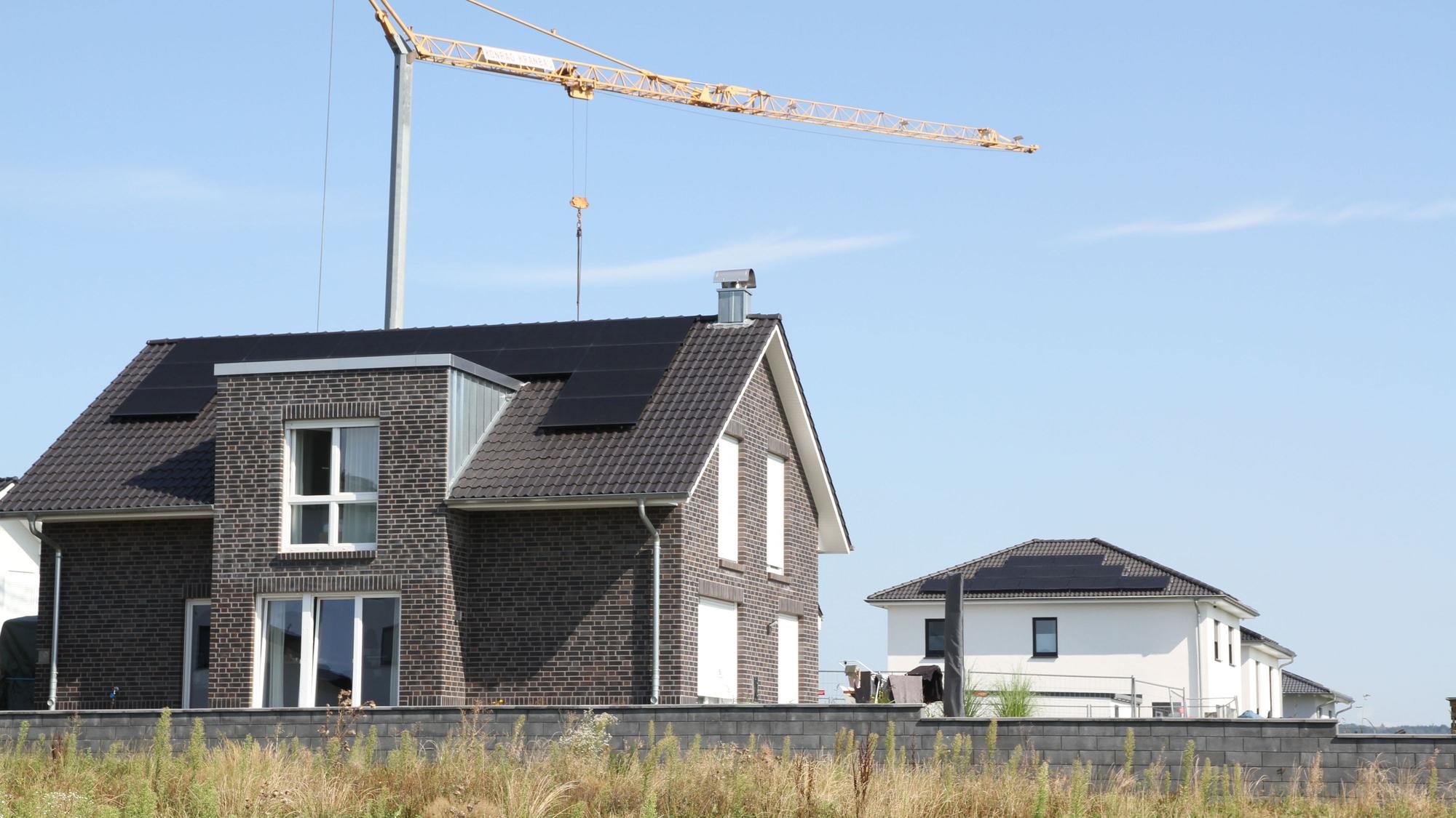 Neugebaute Wohnhäuser mit Photovoltaikanlagen auf dem Dach.