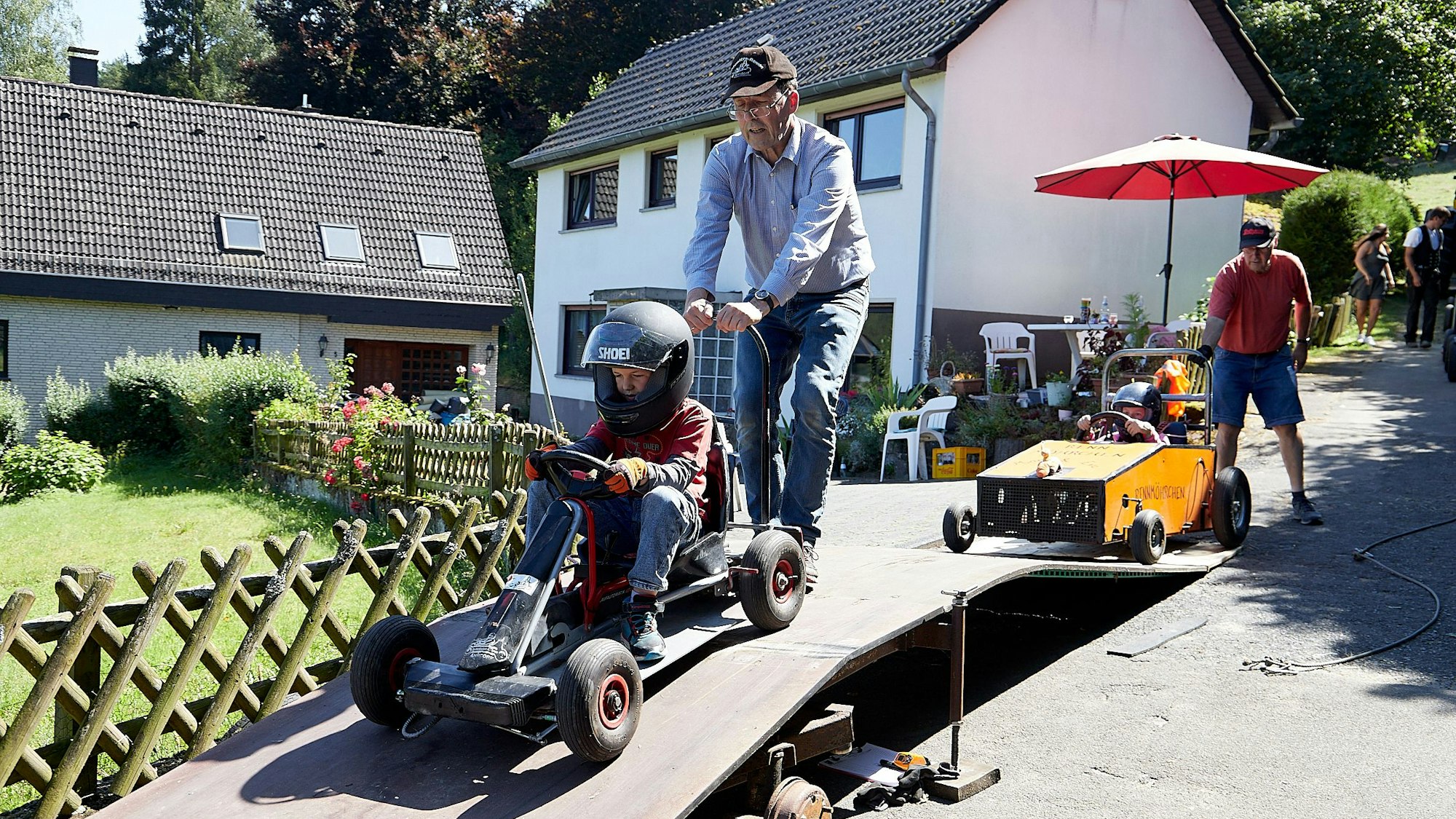 Eine Seifenkiste wird an der Startrampe festgehalten, damit sie nicht losrollt.