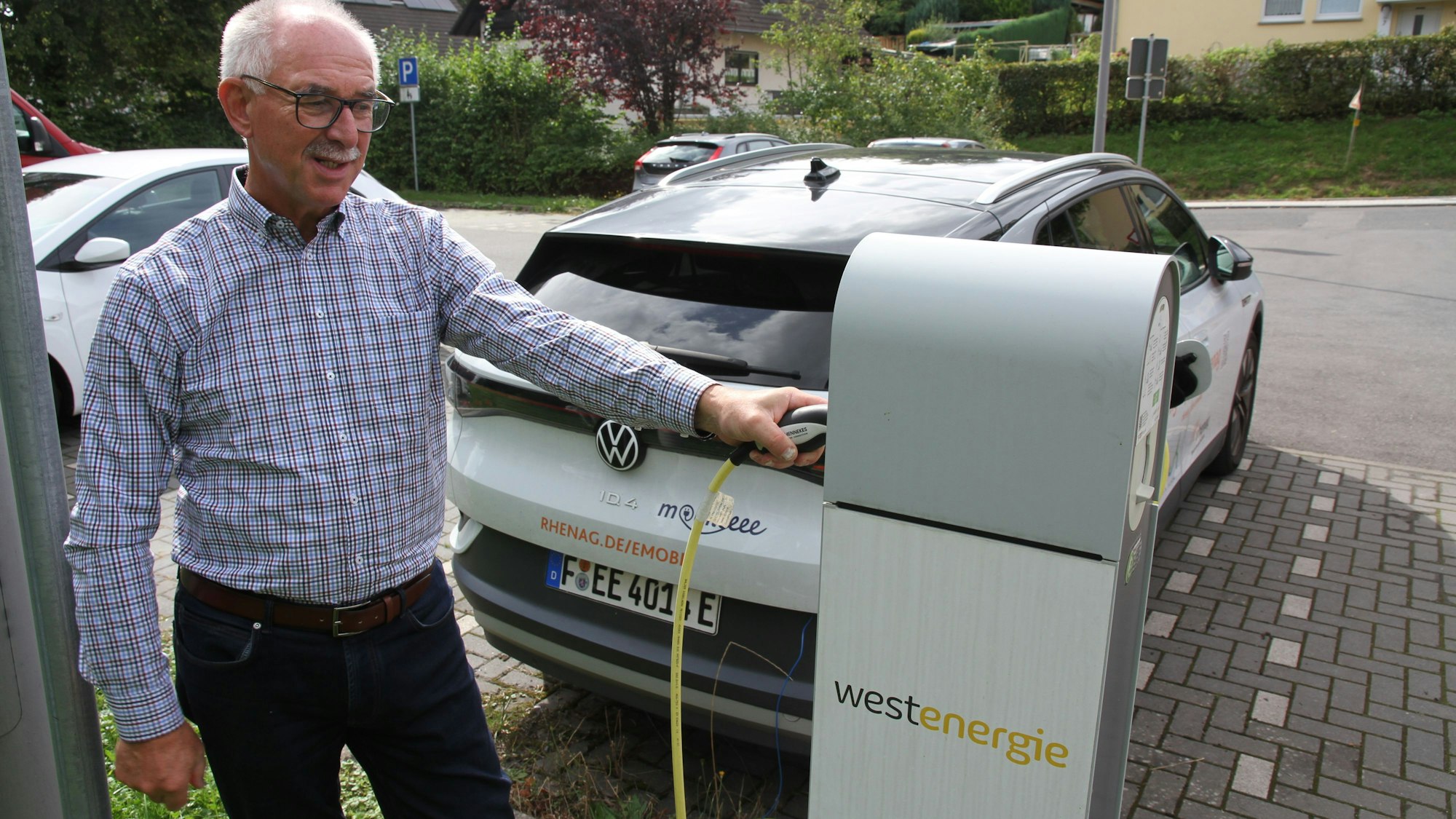 Ein Mann an einer Ladestation für ein Elektroauto