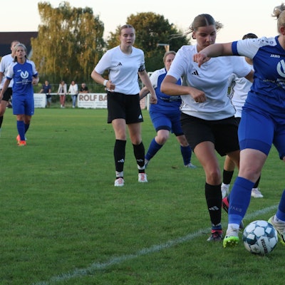 Erfthöhens Spielerin schirmt den Ball gegen eine Kommerner Gegenspielerin ab. Der Schiedsrichter schaut ganz genau hin, ob alles mit rechten Dingen zugeht.