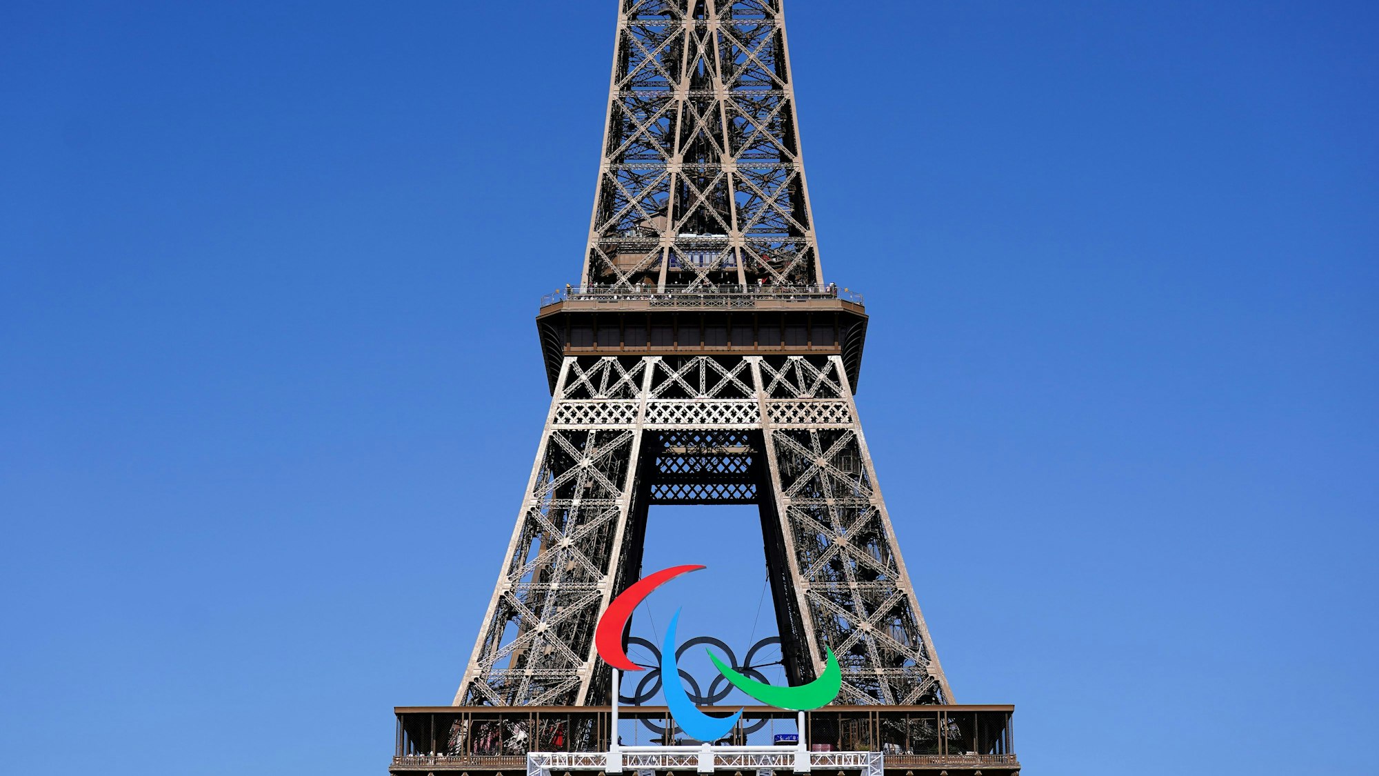 Das Agitos-Logo ist im Vorfeld der Paralympischen Sommerspiele 2024 unterhalb des Eiffelturms zu sehen.