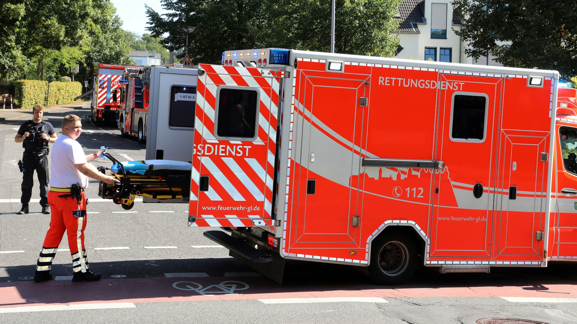 Ein Rettungsassistent holt eine Trage aus einem Rettungswagen.