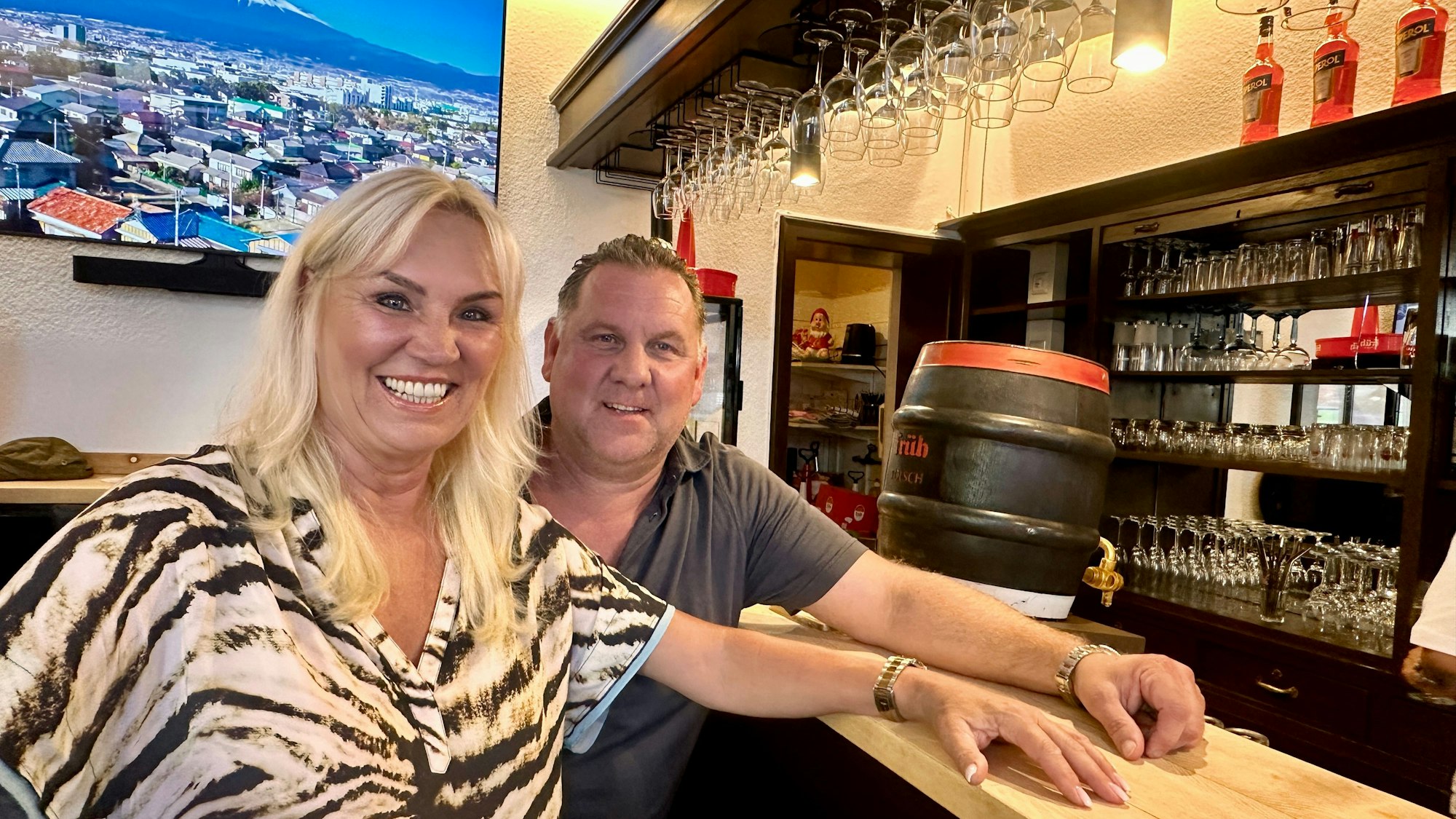 Zu sehen sind Tanja Korsch und Marc Schirmer, die an der Theke der Maternusstube in Köln-Rodenkirchen sitzen.