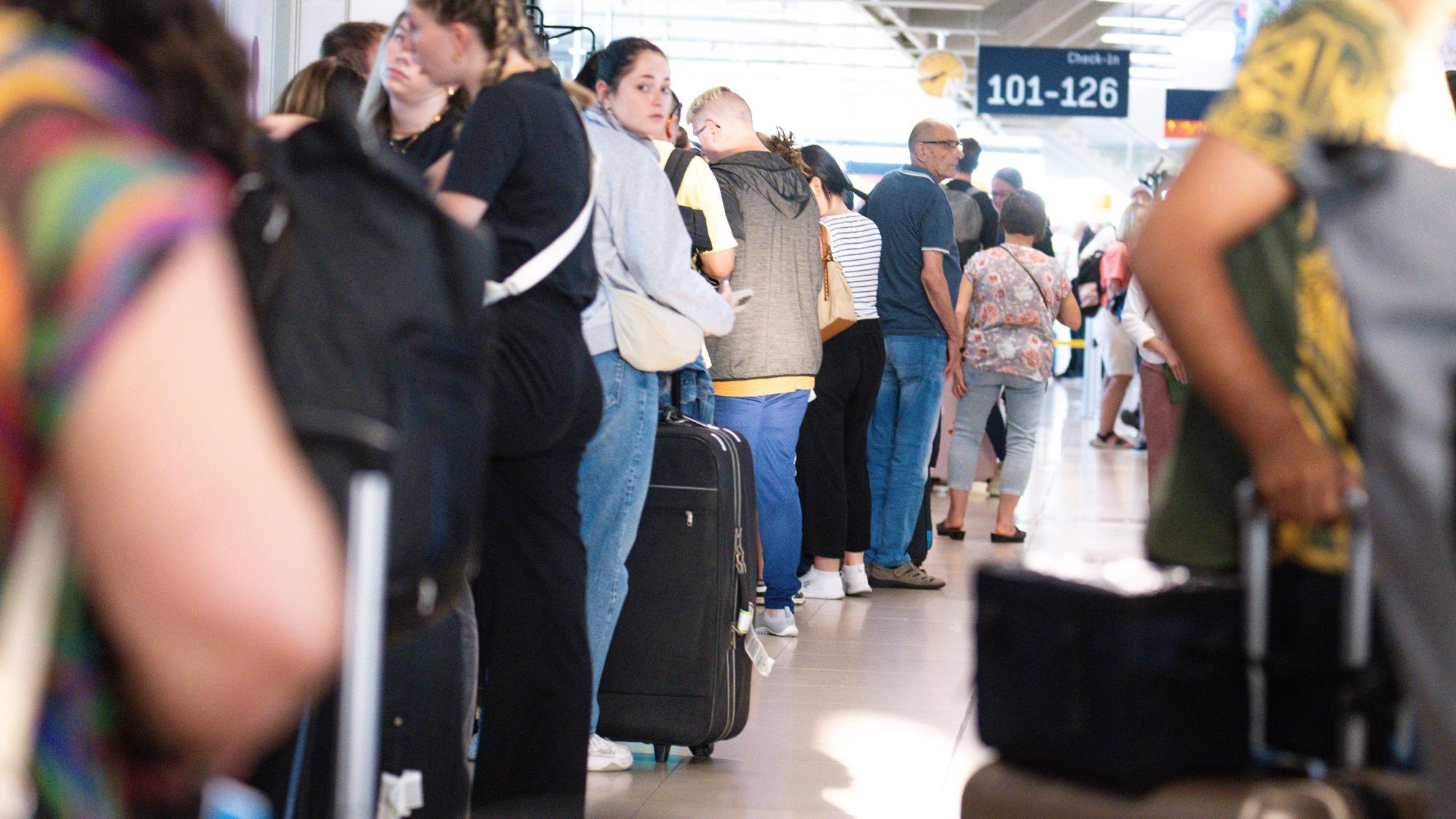 Fluggäste stehen in einer Schlange am Flughafen.