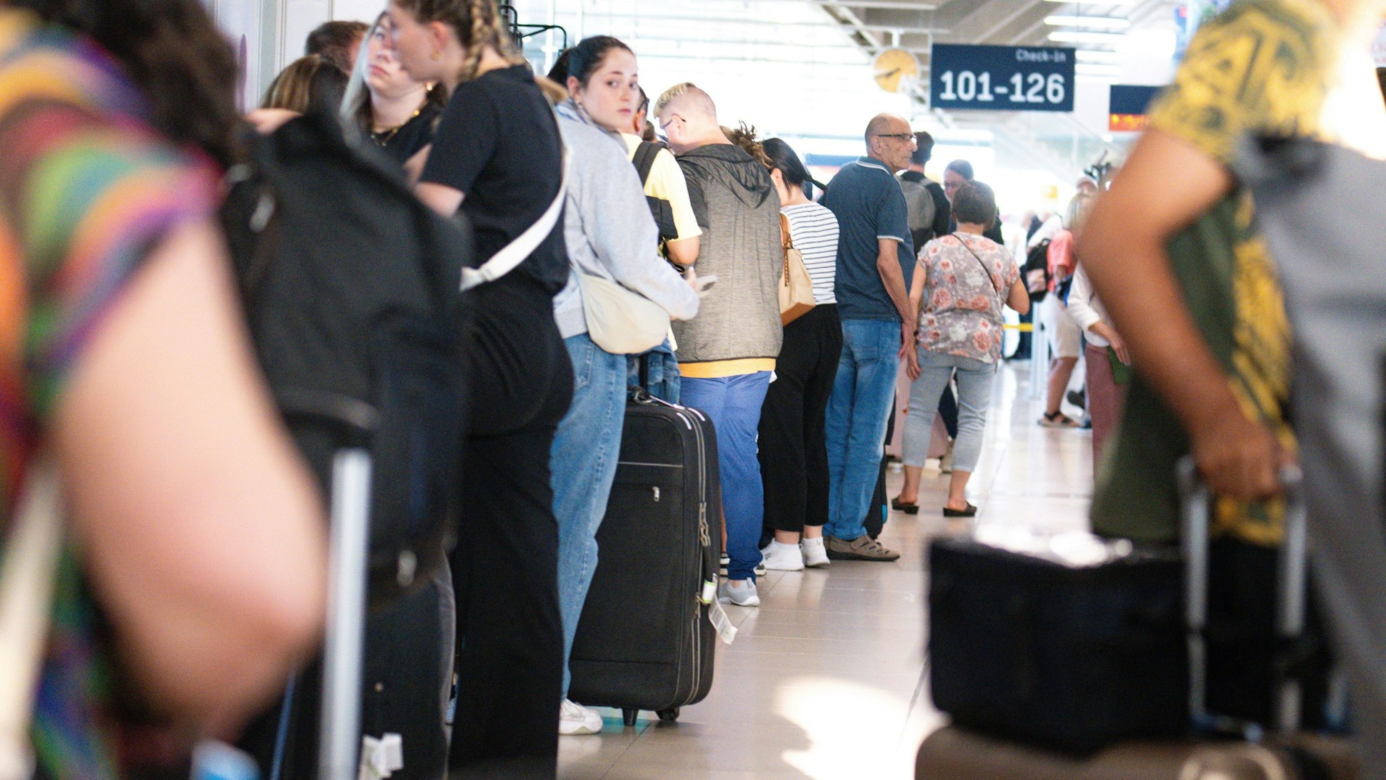 Fluggäste stehen in einer Schlange am Flughafen.