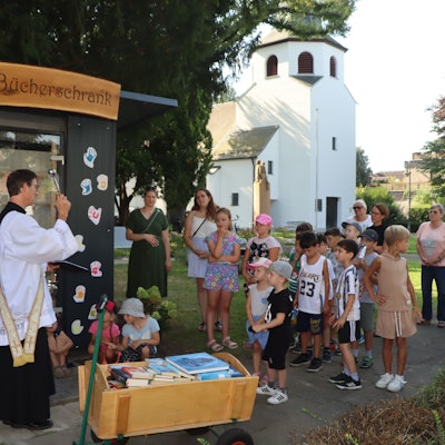 Auf dem Bild ist die Einsegnung des neuen Bücherschrankes zu sehen.