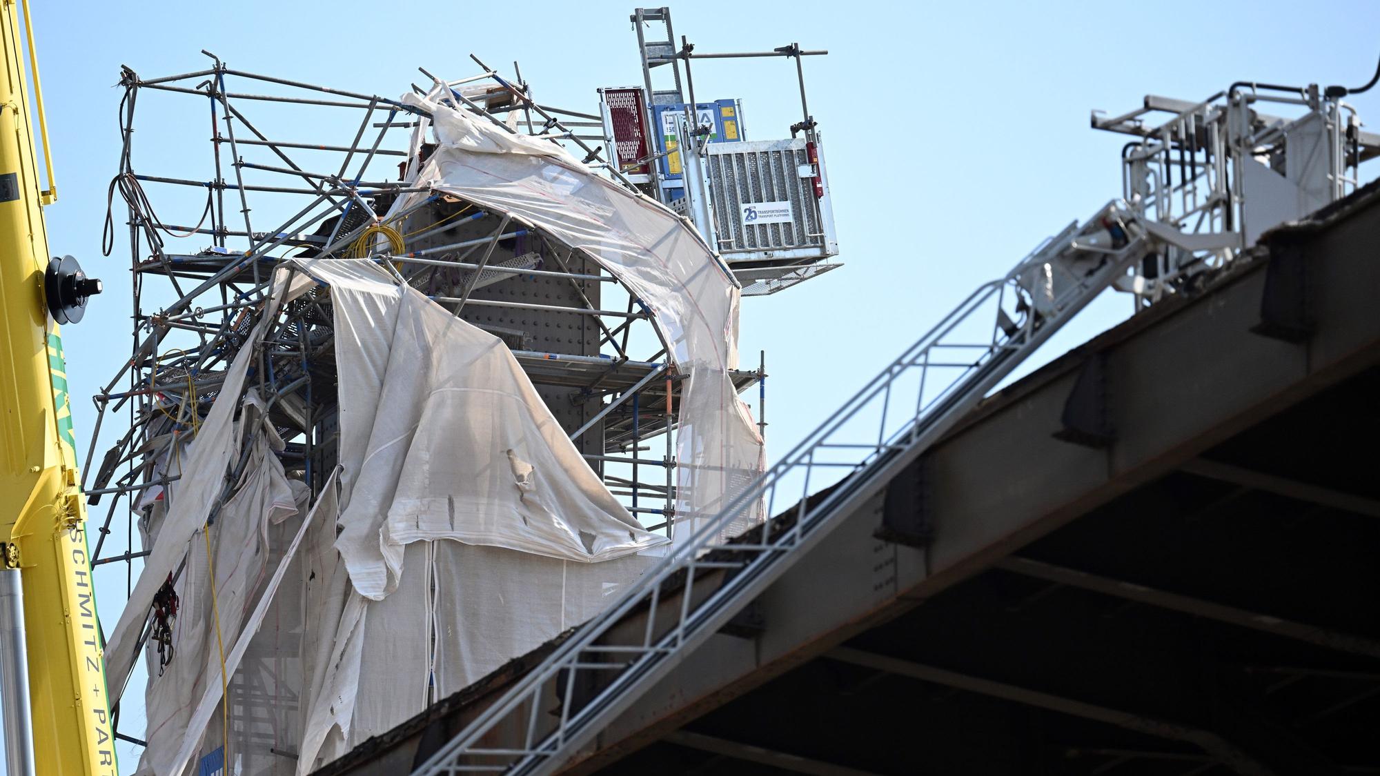 Leverkusen: Verbogene Gerüstteile hängen an dem Pfeiler der Leverkusener Brücke.