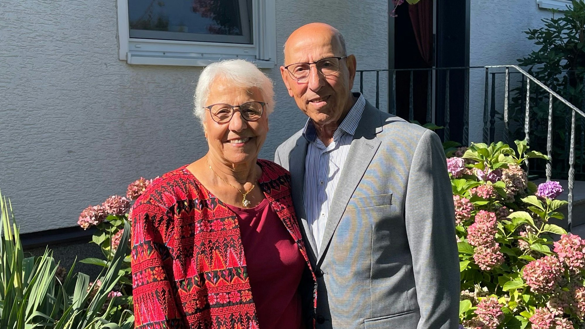 Fadua und Anton Rishmawi stehen in ihrem Garten nebeneinander.