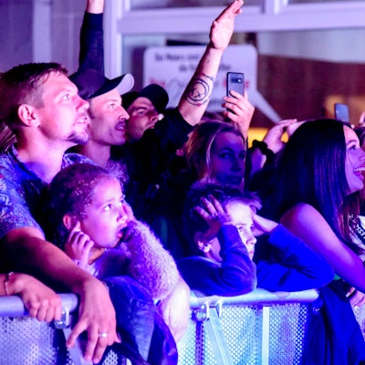 Das Foto zeigt junge Besucherinnen und Besucher hinter dem Absperrgitter vor der Bühne.