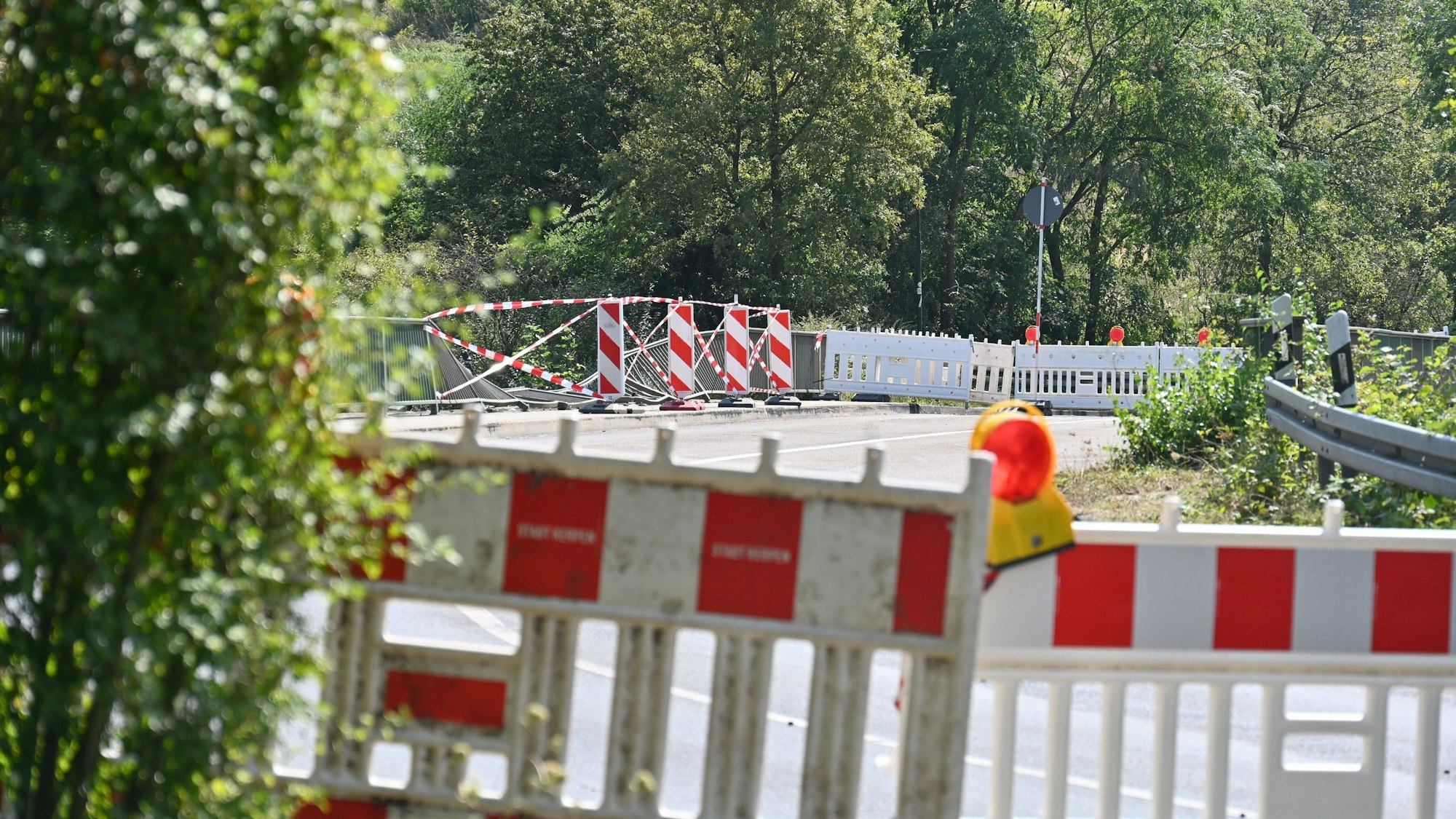 Zu sehen ist eine abgesperrte Brücke, auf der ein Teil des Geländers beschädigt ist.