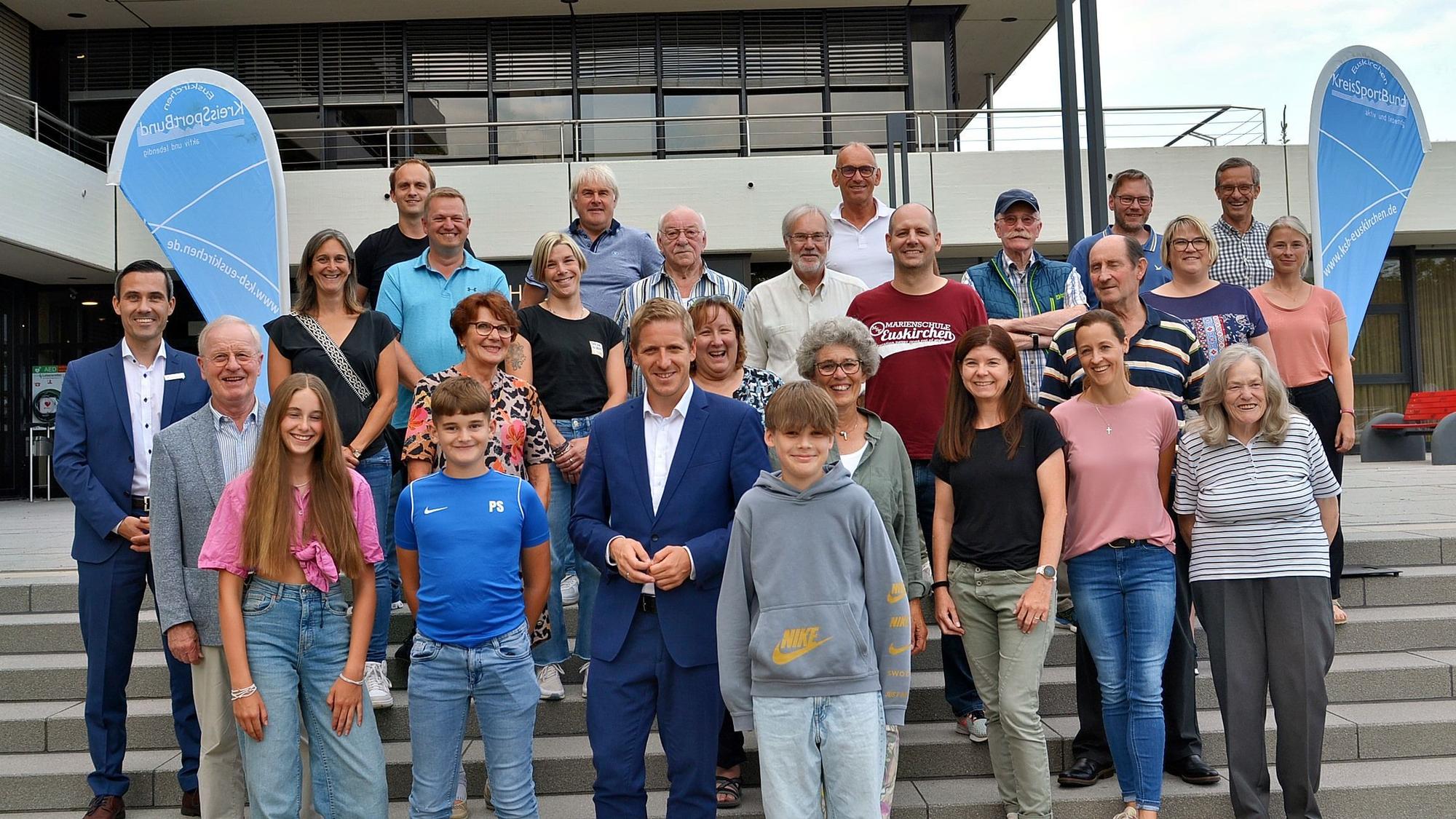 Die Geehrten stehen mit Landrat Markus Ramers auf der Treppe am Euskirchener Kreishaus.