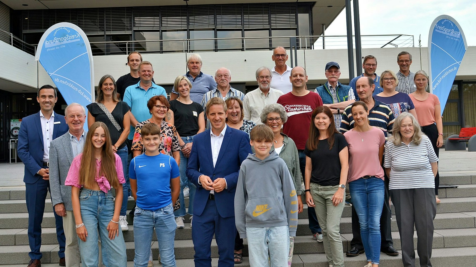 Die Geehrten stehen mit Landrat Markus Ramers auf der Treppe am Euskirchener Kreishaus.
