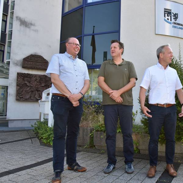 Vier Männer stehen vor dem Oberbergischen Kreishaus beisammen.