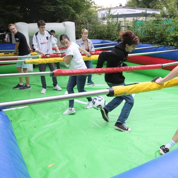 Junge Leute spielen Menschenkicker.