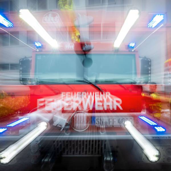 Ein Löschfahrzeug der Feuerwehr spiegelt sich frontal in einer Scheibe.