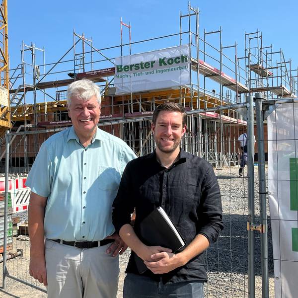Nümbrechts Bürgermeister Hilko Redenius und Fachbereichsleiter Jan Förster stehen vor einem Gebäude, das gerade gebaut wird.