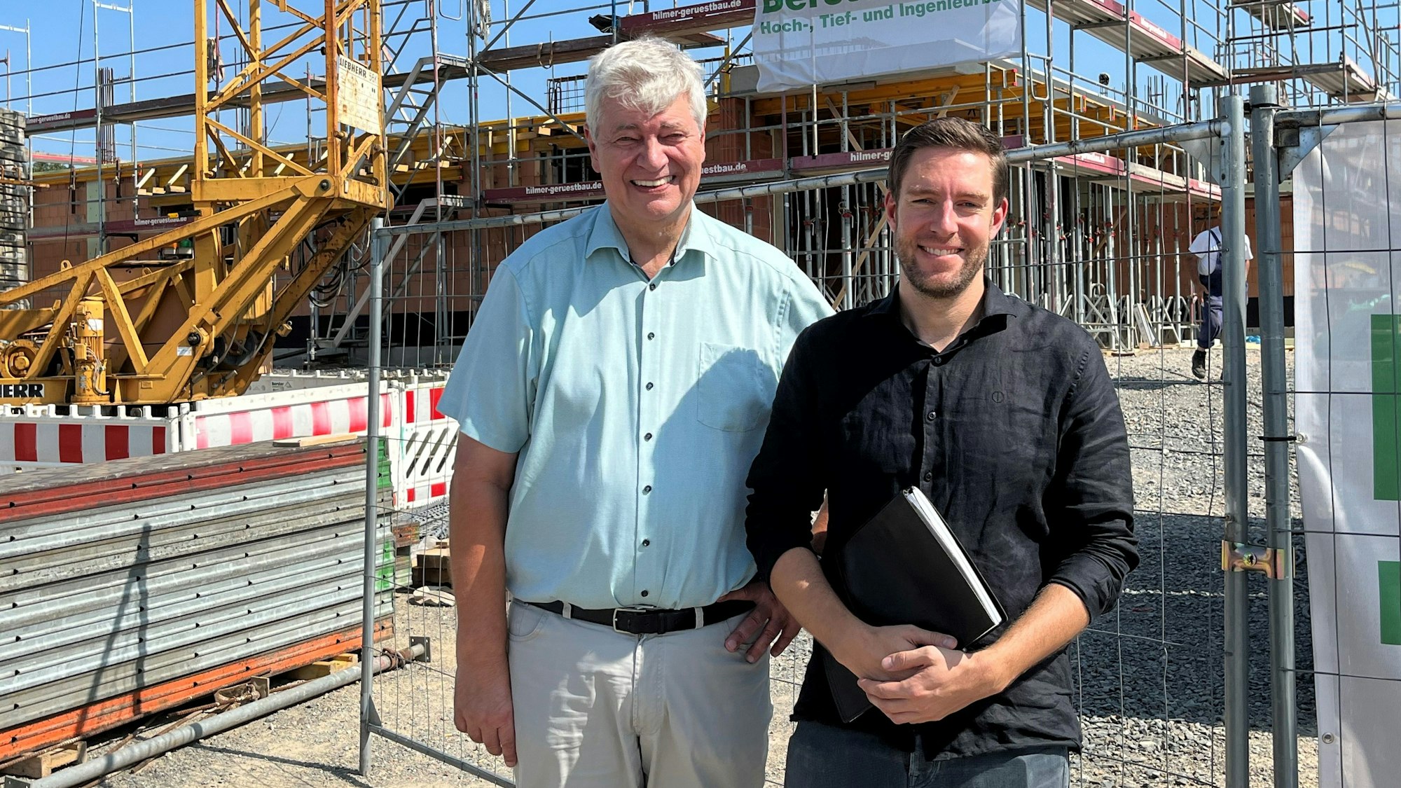 Nümbrechts Bürgermeister Hilko Redenius und Fachbereichsleiter Jan Förster stehen vor einem Gebäude, das gerade gebaut wird.