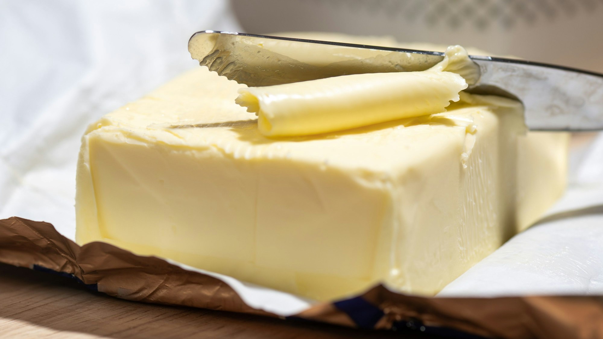 Ein Stück Butter liegt auf einem Tisch. (Symbolbild)