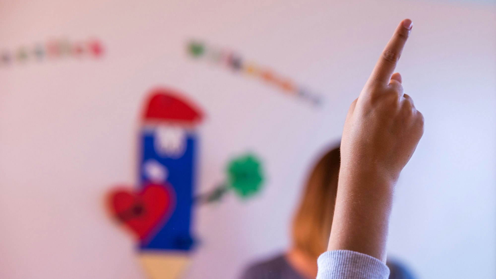 Ein Schüler meldet sich im Klassenraum einer Grundschule.