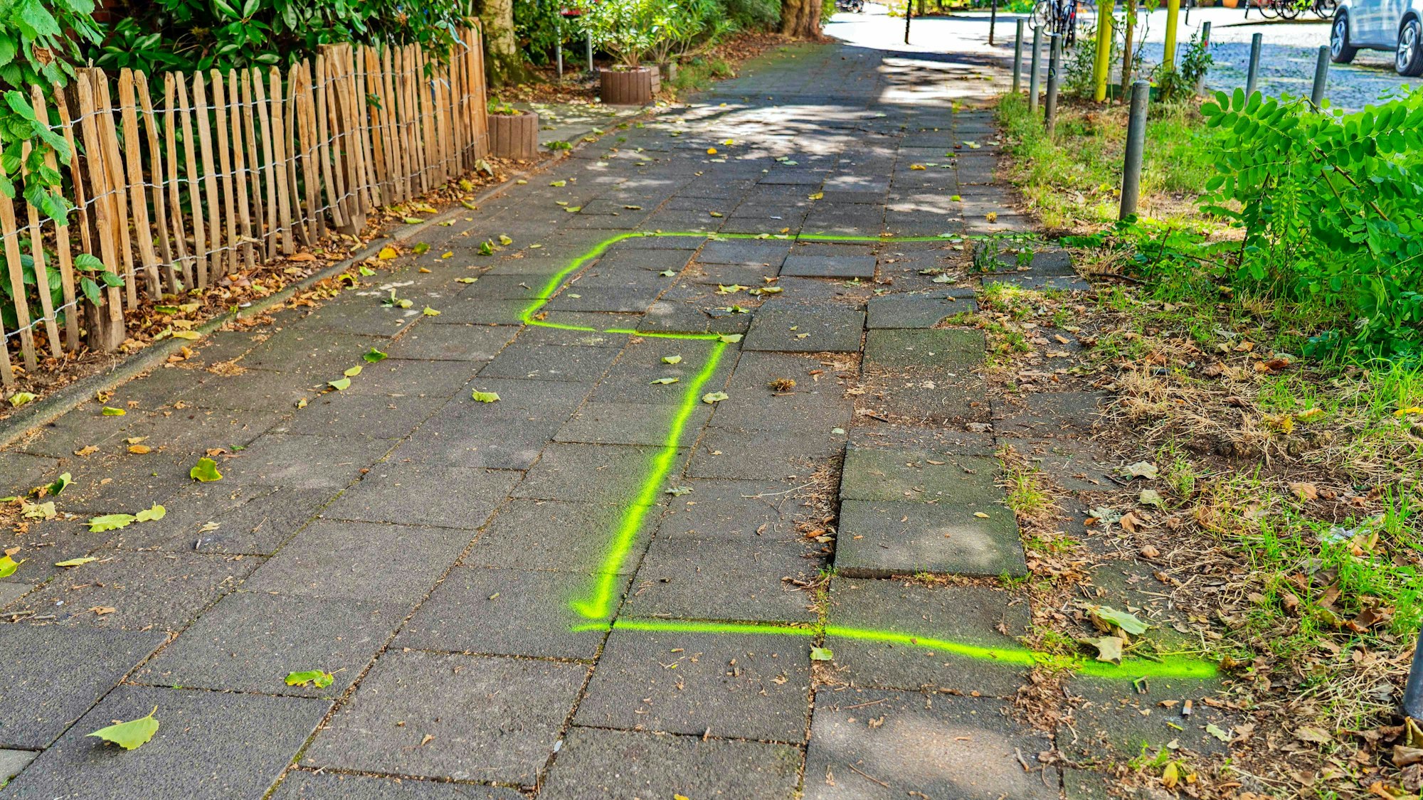 Die Baumwurzeln haben Gehwegplatten angehoben. Die gefährliche Stolperstelle wurde am 27. August von der Stadt markiert.