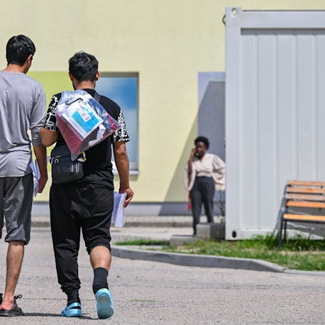 Zwei Migranten gehen über das Gelände der Zentralen Erstaufnahmeeinrichtung für Asylbewerber.
