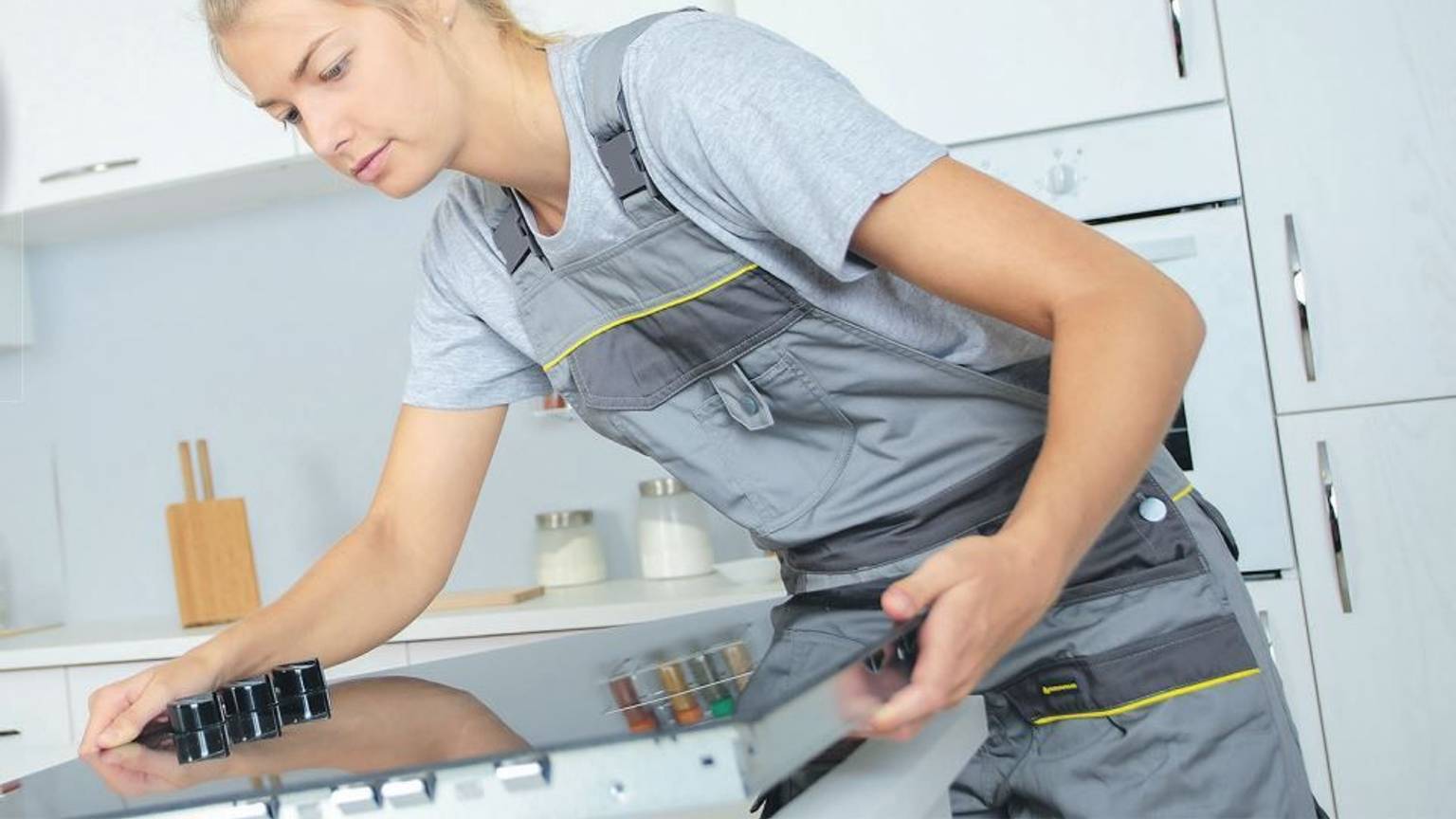 Handwerkerin beim Einbau eines Herdes.