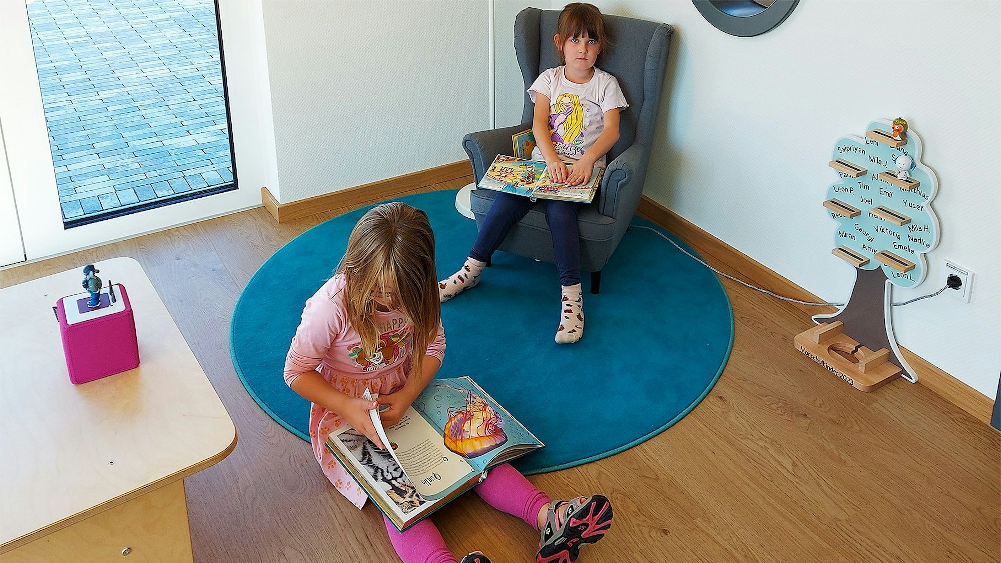 Zwei Mädchen blättern in Büchern.