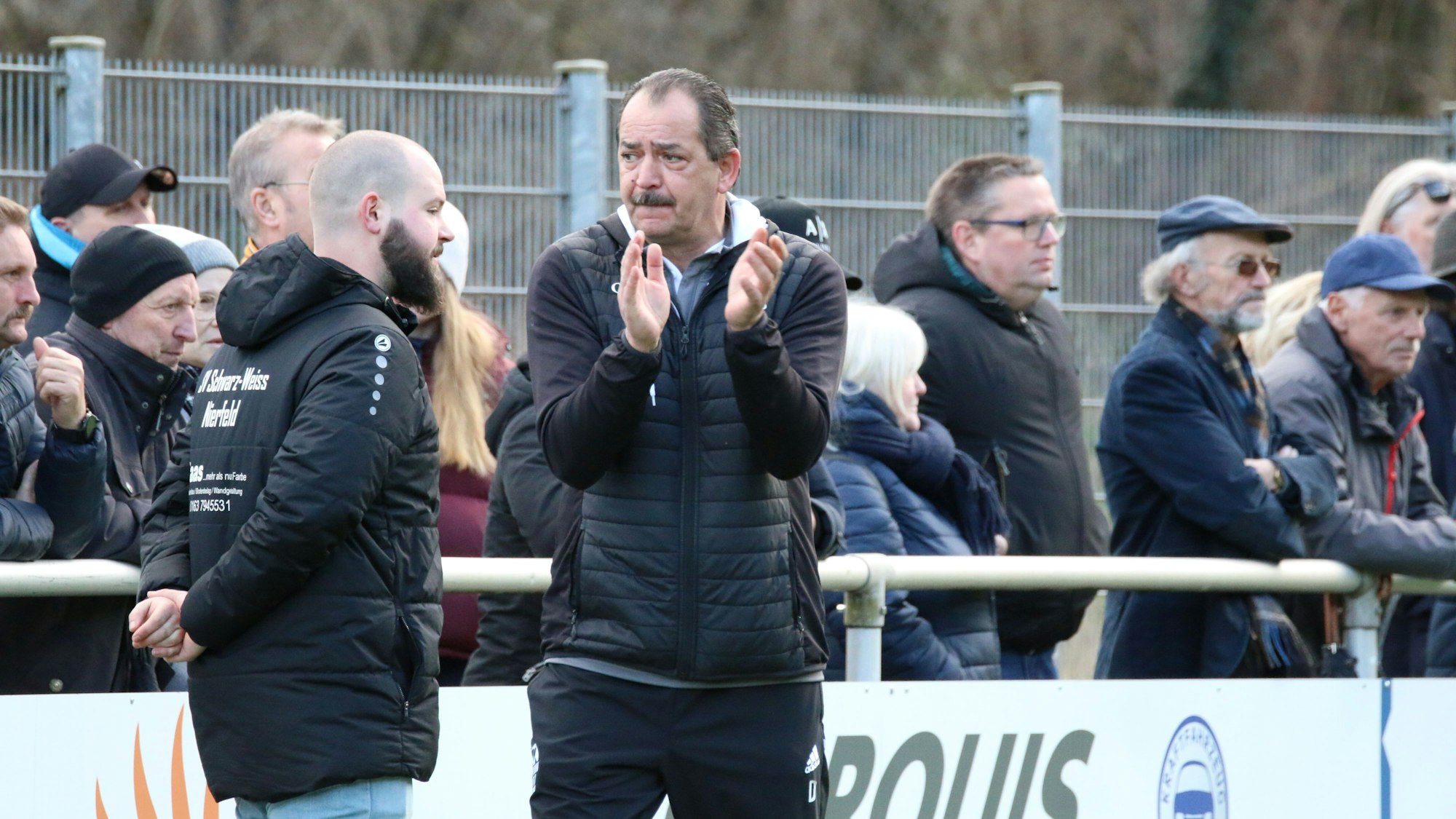 Nierfelds Trainer Dirk Scheer applaudiert seiner Mannschaft. Im Hintergrund stehen die Zuschauer.