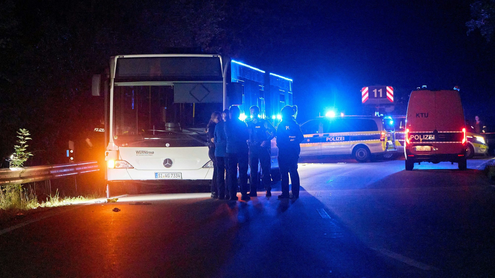 30.08.2024, Nordrhein-Westfalen, Siegen: Polizisten stehen vor einem Bus, der auf einer Sonderlinie zu einem Stadtfest fahren sollte. Eine 32-jährige Tatverdächtige habe in dem Bus andere Fahrgäste mutmaßlich mit einem Messer angegriffen. Es gebe mehrere Verletzte aber keinerlei Hinweise auf einen terroristischen Hintergrund, teilte die Polizei mit. Foto: Sascha Ditscher/dpa +++ dpa-Bildfunk +++