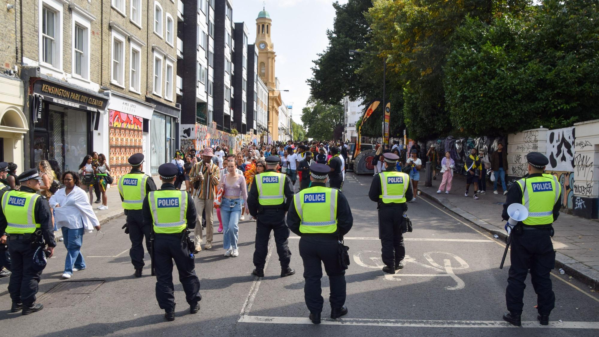 Polizeibeamte beobachten die Menschenmenge am zweiten Tag des Notting Hill Carnival. Die jährliche Veranstaltung in Londons beliebtem Stadtteil Notting Hill zieht rund eine Million Menschen an und ist vor allem ein Fest der karibischen Kultur.