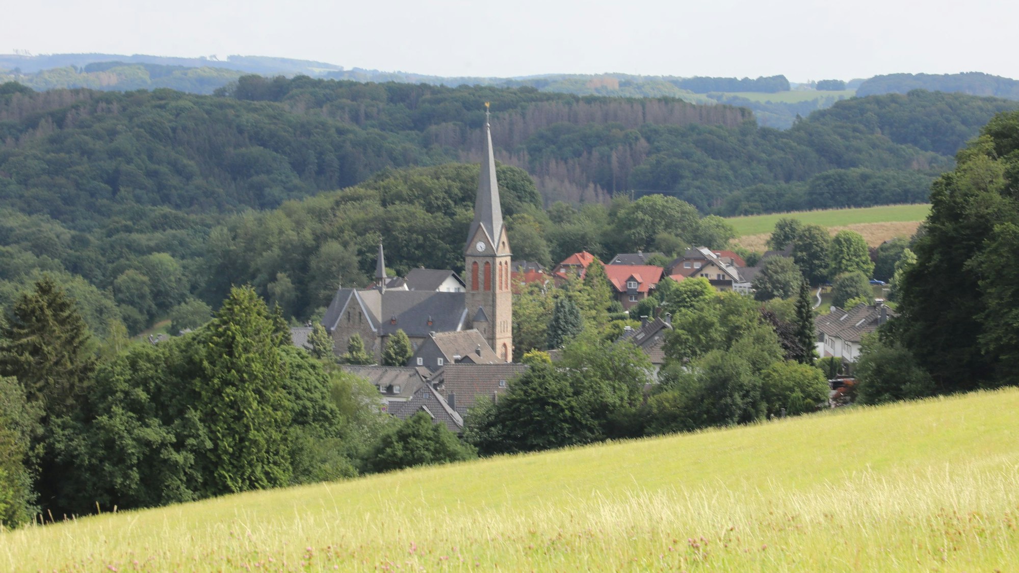 Zwischen Hügeln liegt der Ort Kürten-Olpe mit der Kirche St. Margareta