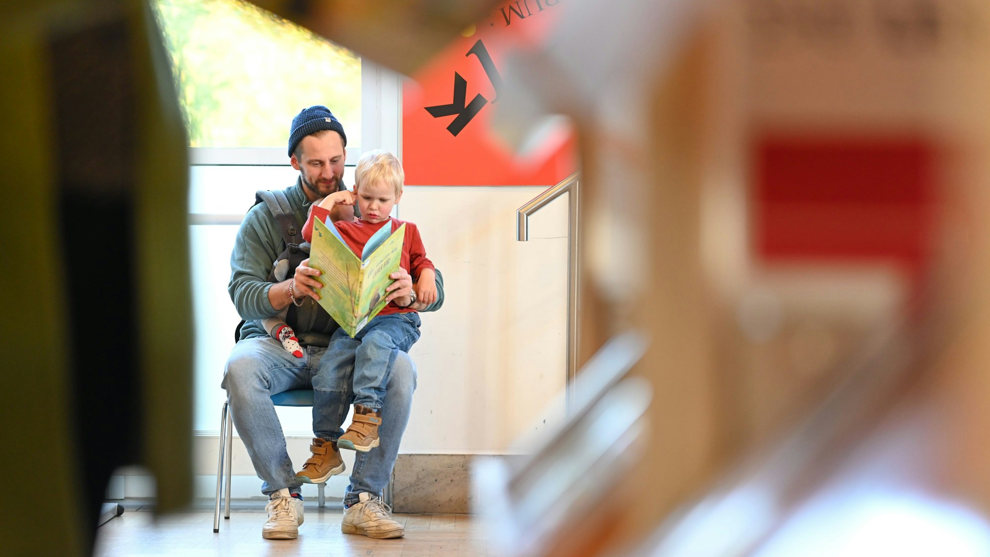 Ein Vater liest seinem Sohn aus einem Kinderbuch vor.