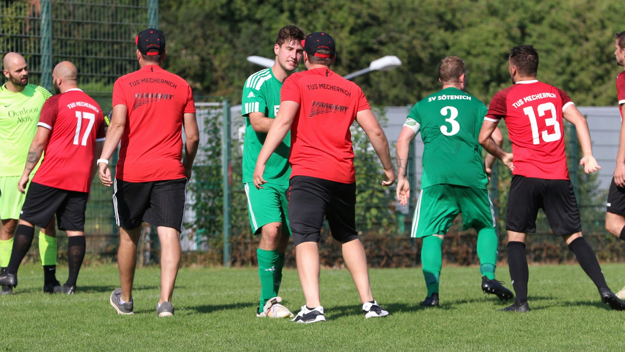 Betreuer von Mechernich sind auf dem Platz und diskutieren mit Sötenicher Spielern. Auslöser war ein Tritt des Torwarts (links).