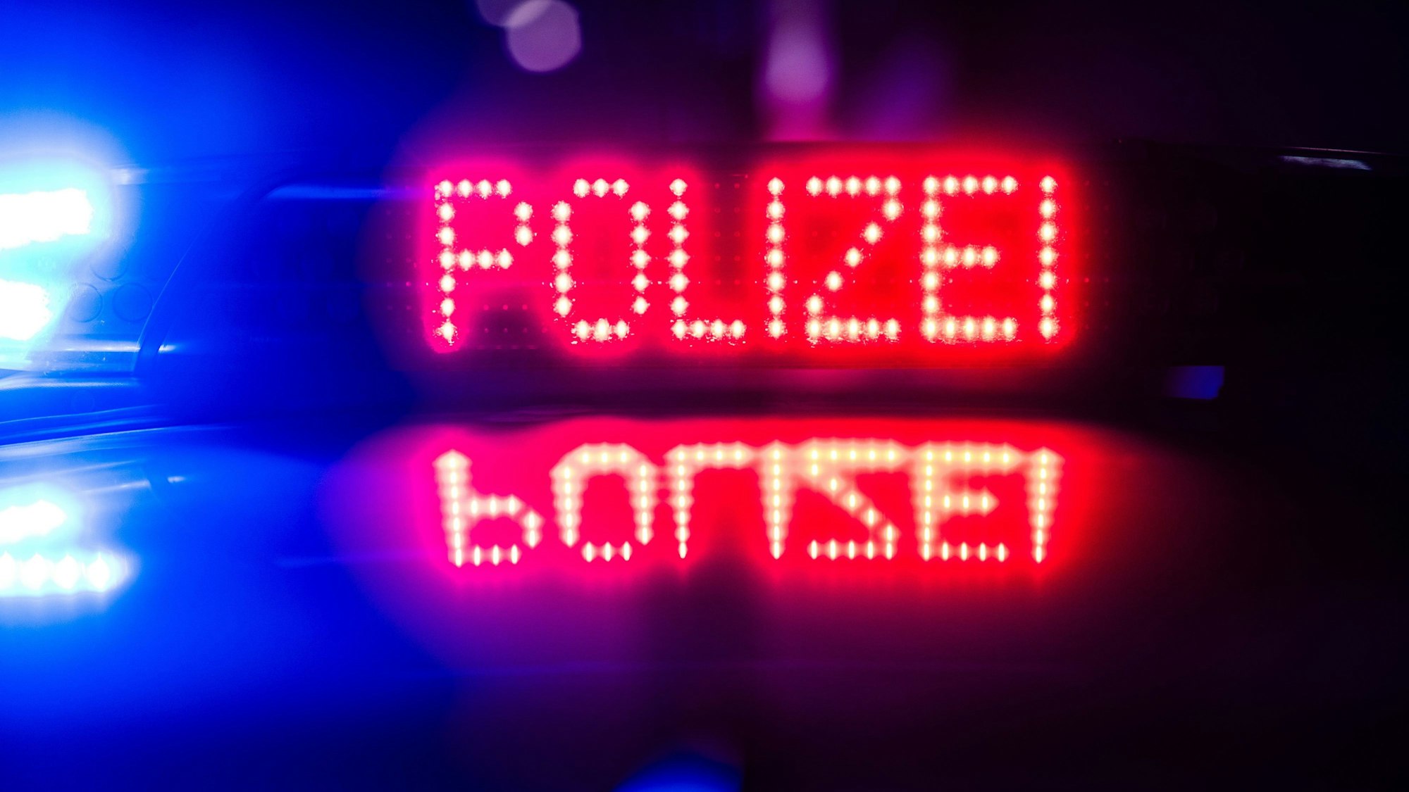 „Polizei“ ist auf dem Dach eines Polizeiautos zu lesen.