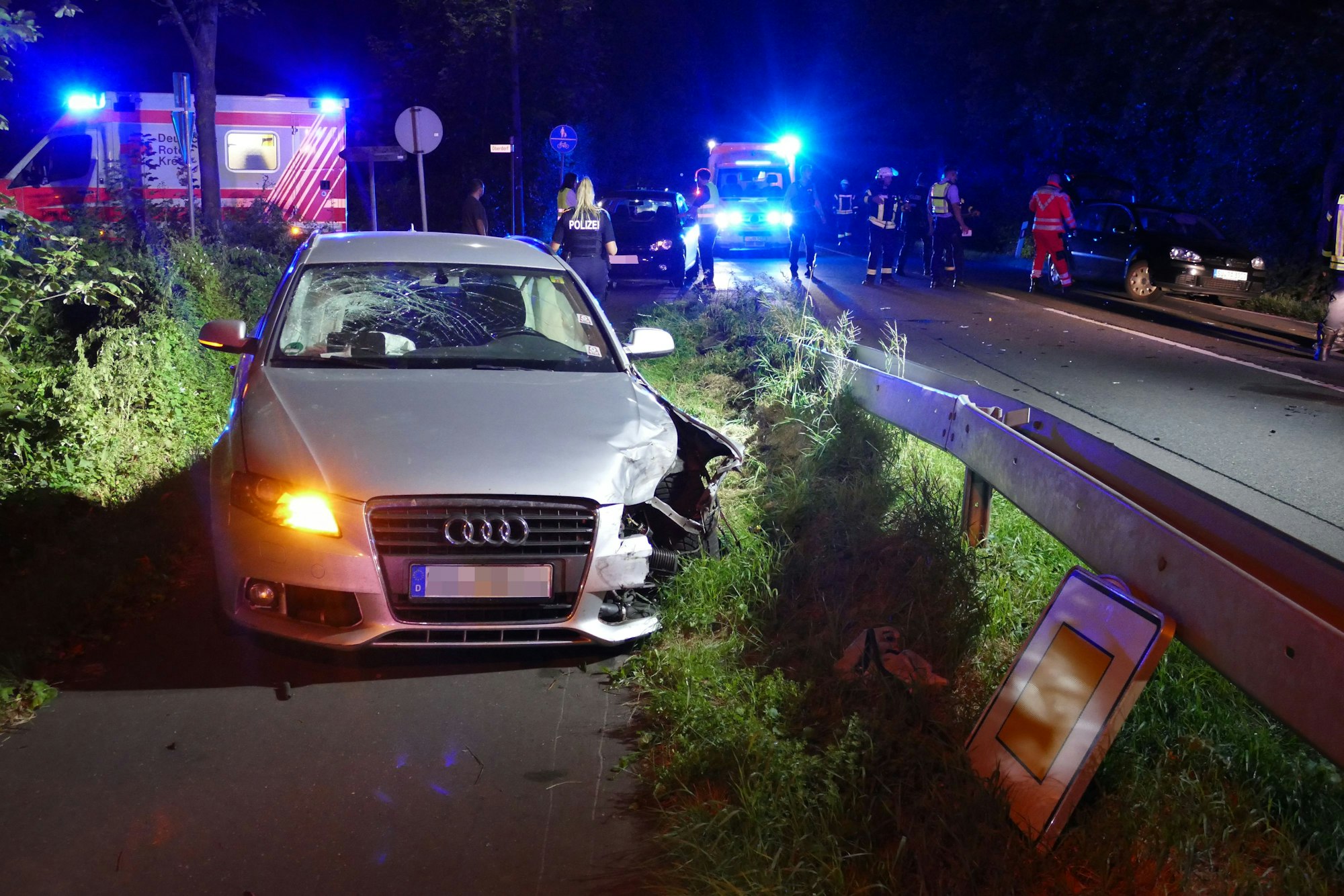 Ein beschädigtes Auto steht auf dem Radweg neben einer Straße.