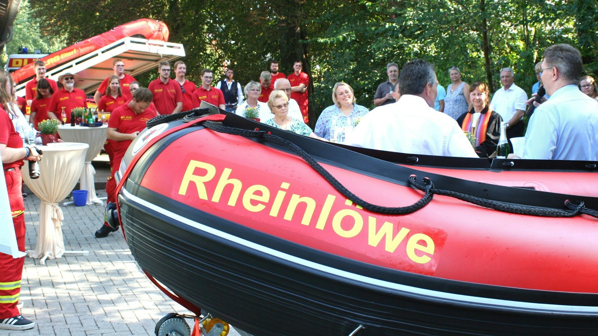 Männer und Frauen neben einem Schlauchboot.