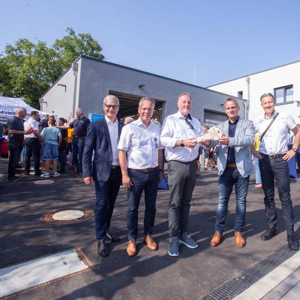 Fünf Herren vor der Rettungswache mit einem symbolischen Schlüssel.