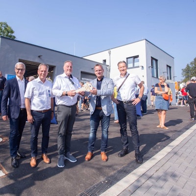 Fünf Herren vor der Rettungswache mit einem symbolischen Schlüssel.