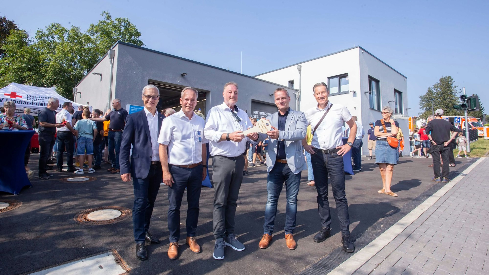 Fünf Herren vor der Rettungswache mit einem symbolischen Schlüssel.