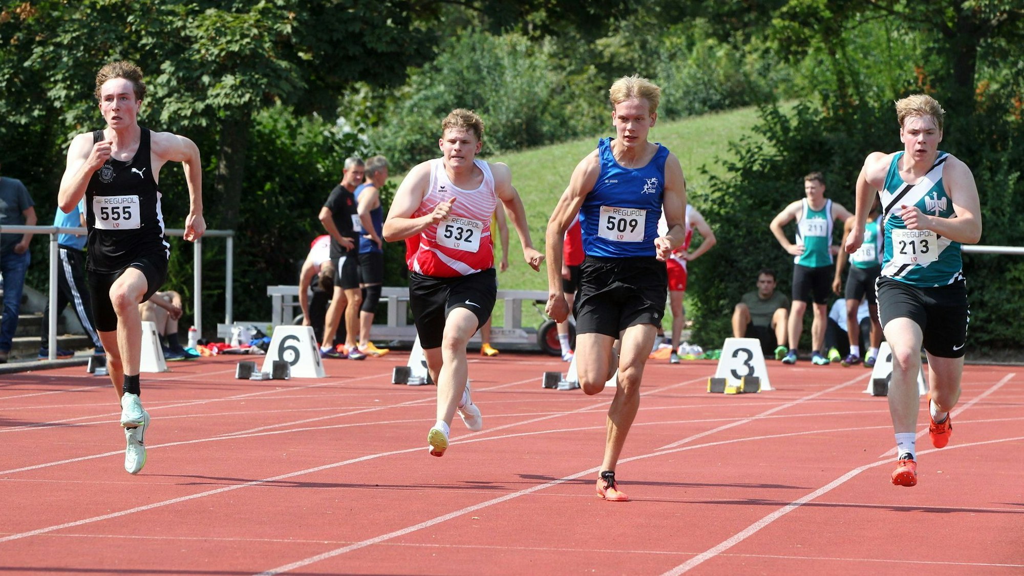 Vier Läufer sind beim 100-Meter-Lauf auf der Strecke.