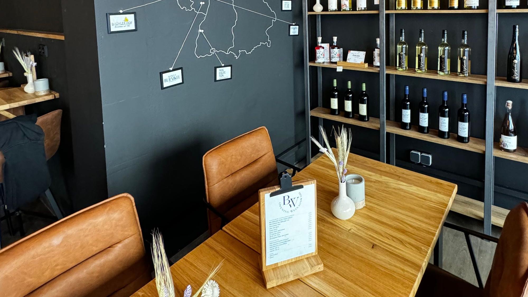 Schick und edel wirkt das Ambiente im Weinkonzept in Beuel: bequeme, mit braunem Kunstleder bezogene Stühle und die Regale sind mit Weiflaschen gefüllt.